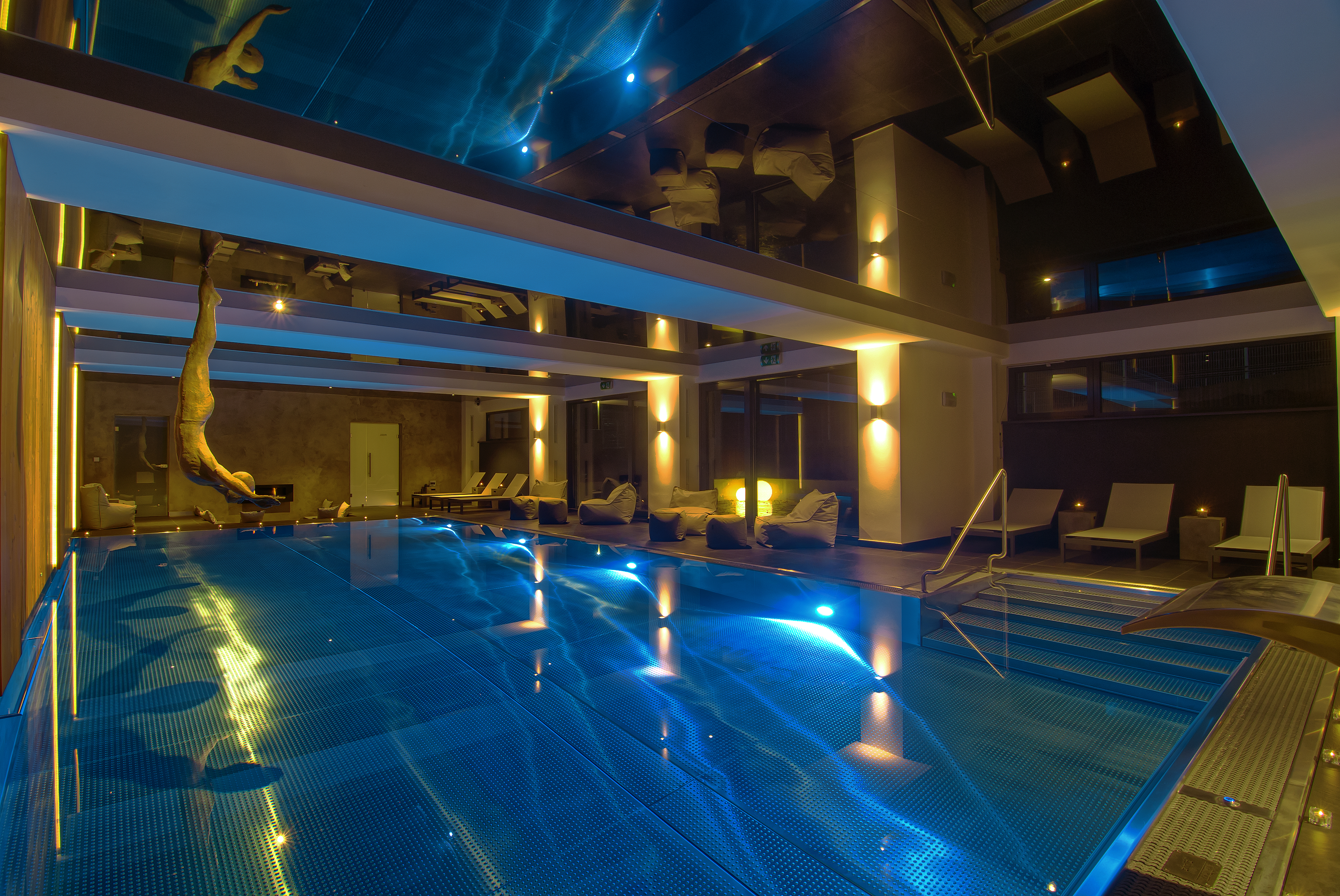 Piscina exterior com iluminação noturna. Referência de ambiente residencial.